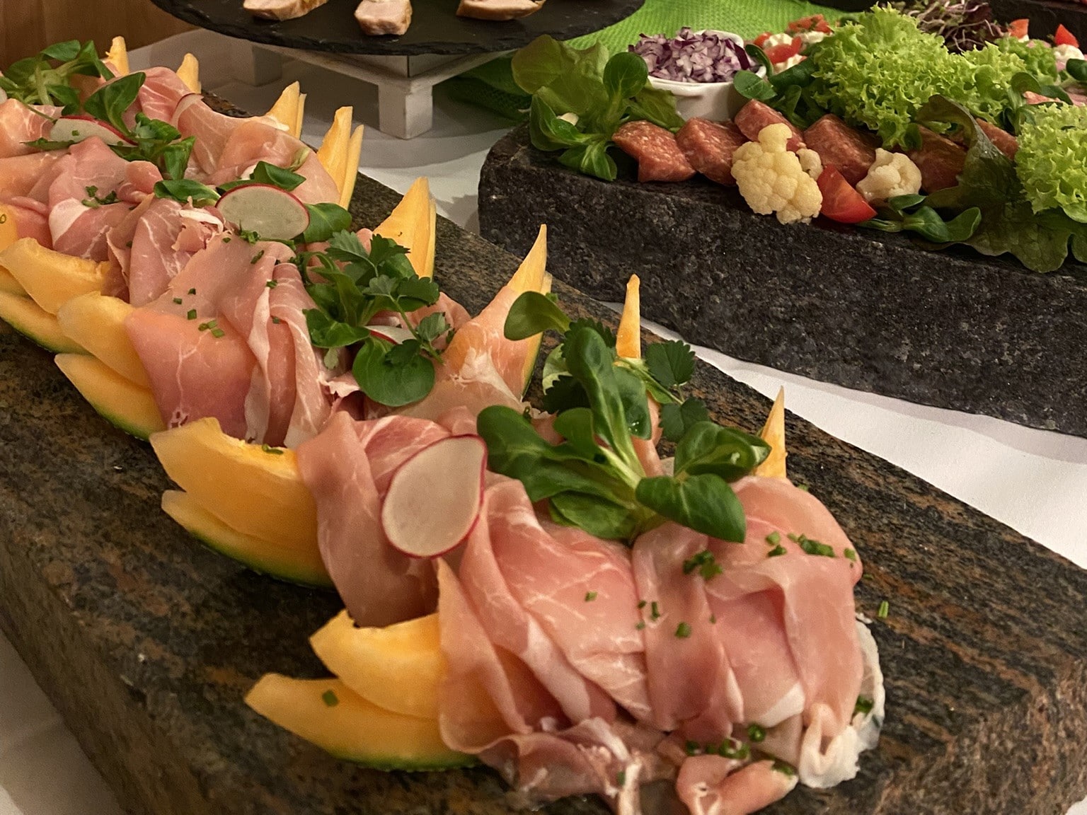 Melone mit Schinken auf Marmorplatte. 